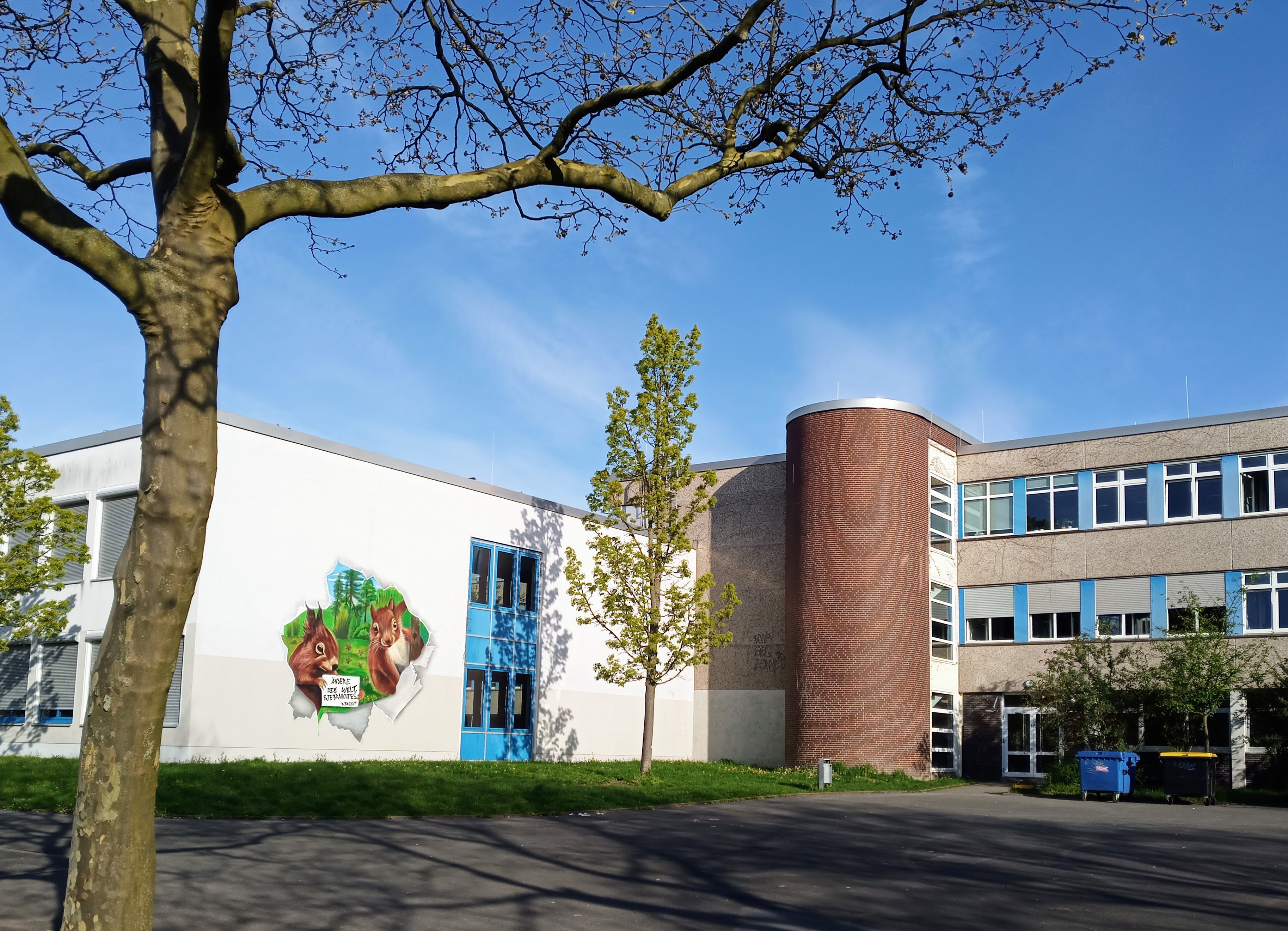 Blick auf das Schulgebäude vom Parkplatz aus